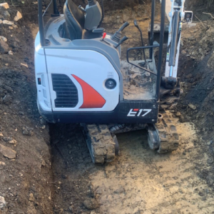 mini excavator working inside a trench