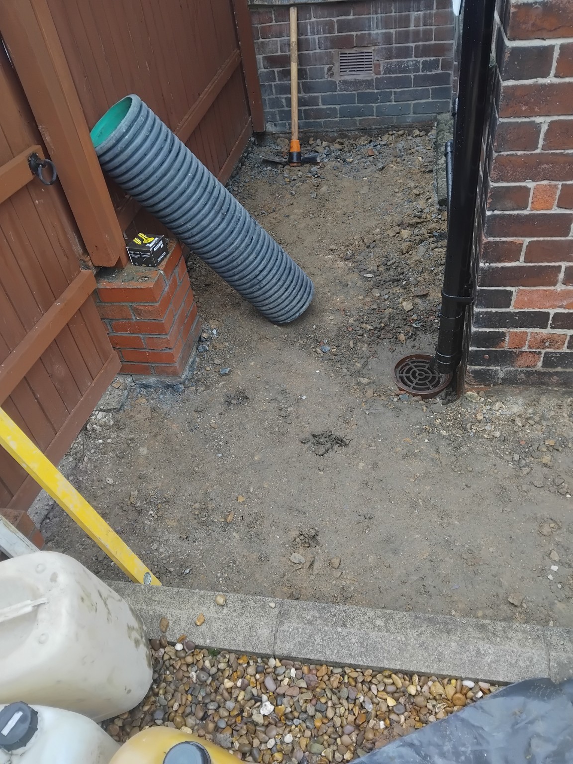 Prepared ground beside a gate before laying the concrete path