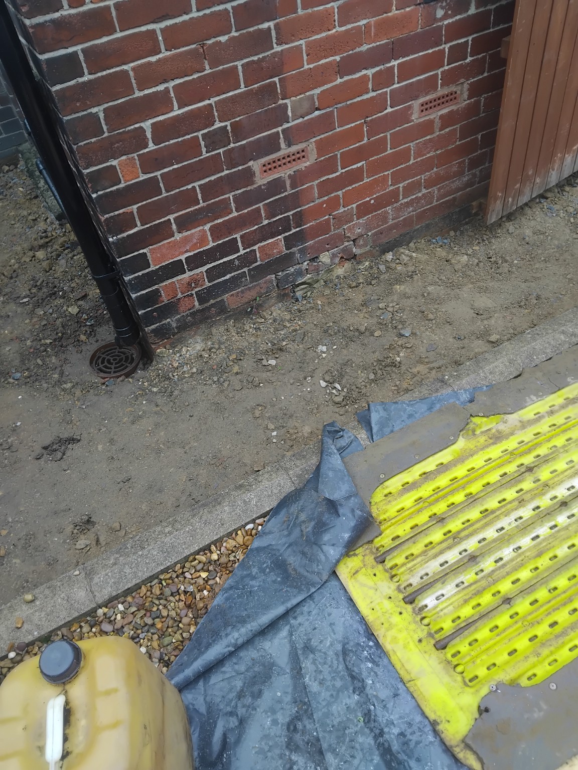 Excavated ground alongside a brick wall before concreting