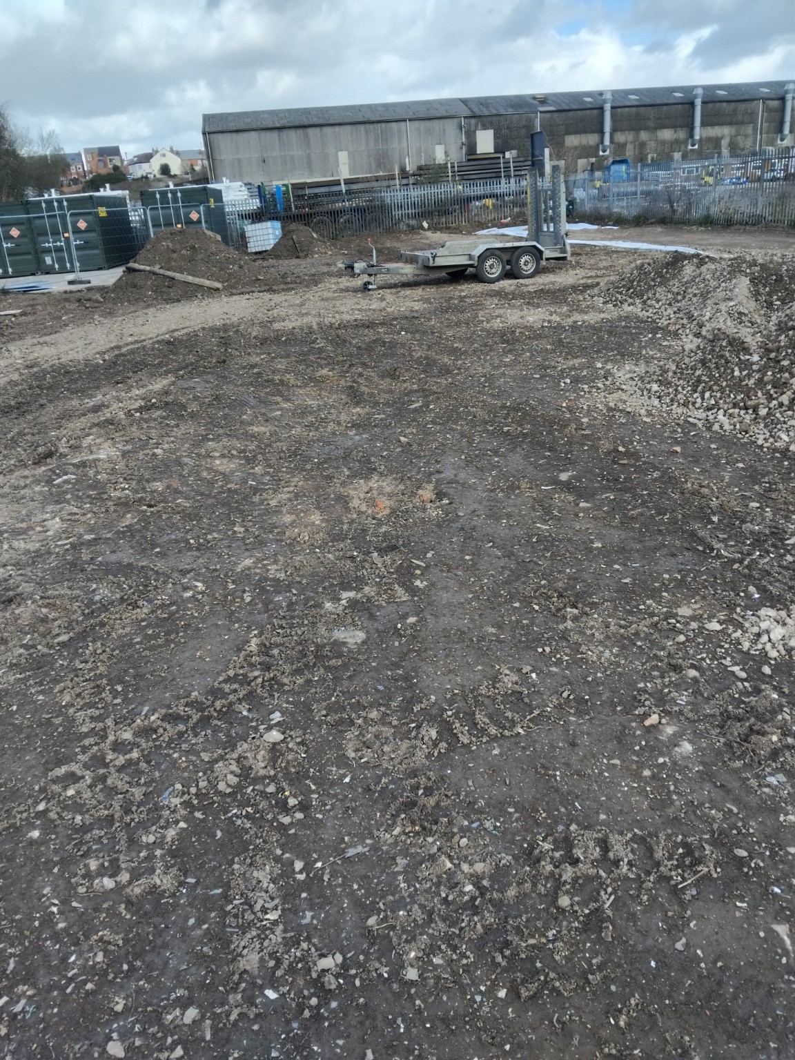 Container storage site during ground preparation with aggregate and a plant trailer