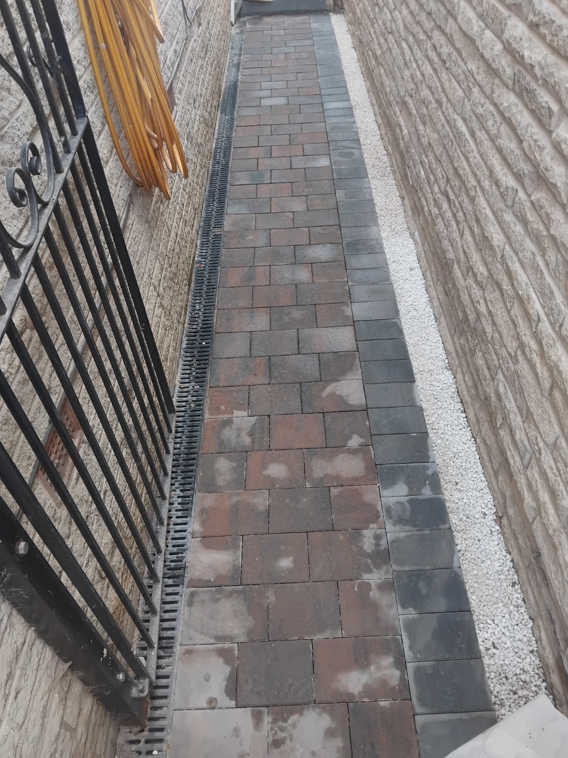 Completed block paved path with dark edging, white gravel and channel drainage