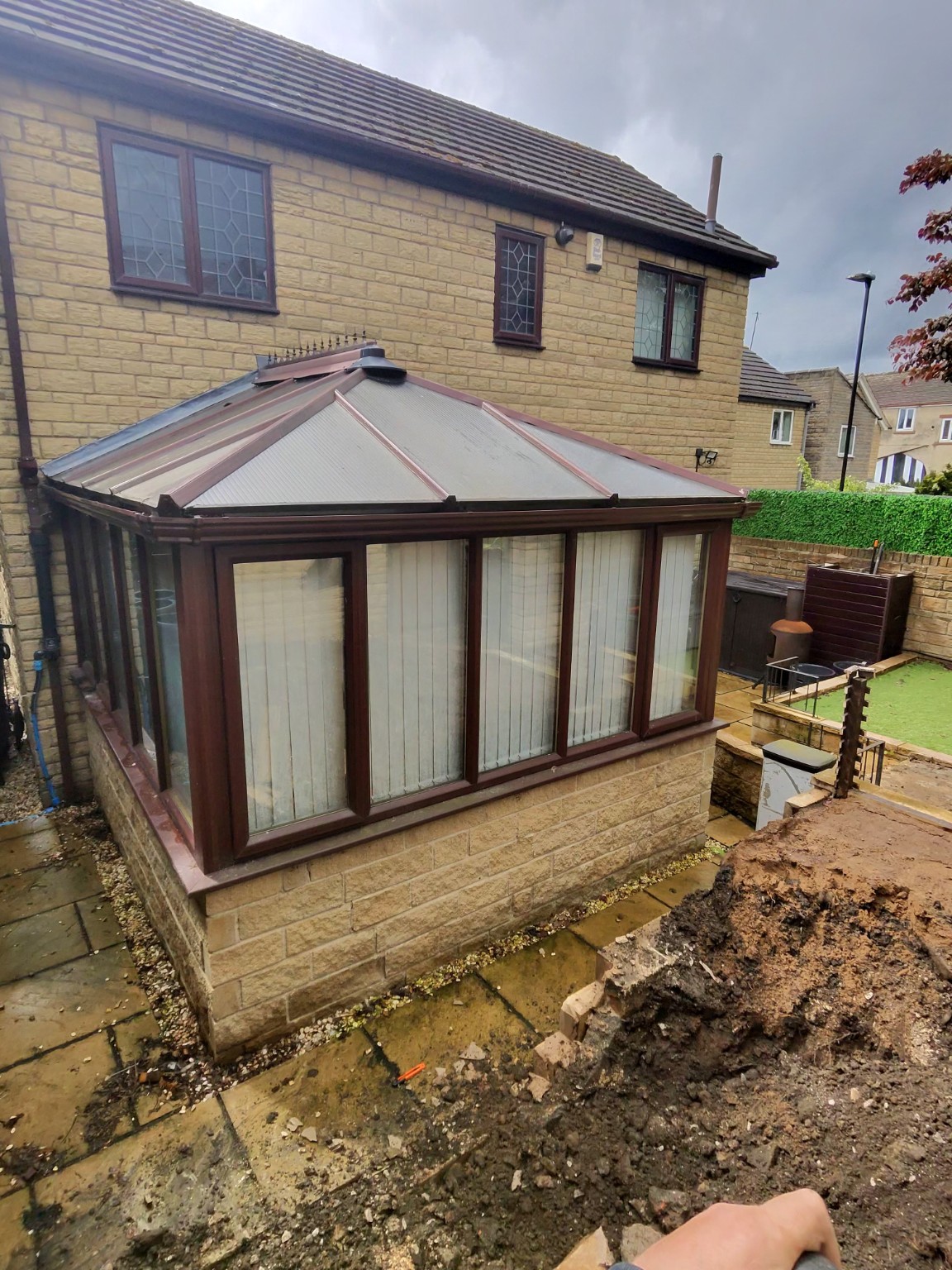 Excavated ground beside a conservatory during extension groundwork