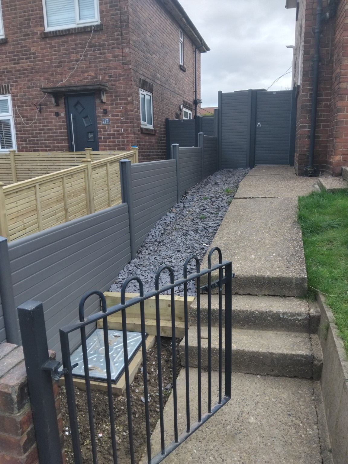 Grey boundary fencing and gate alongside the neighbouring access path