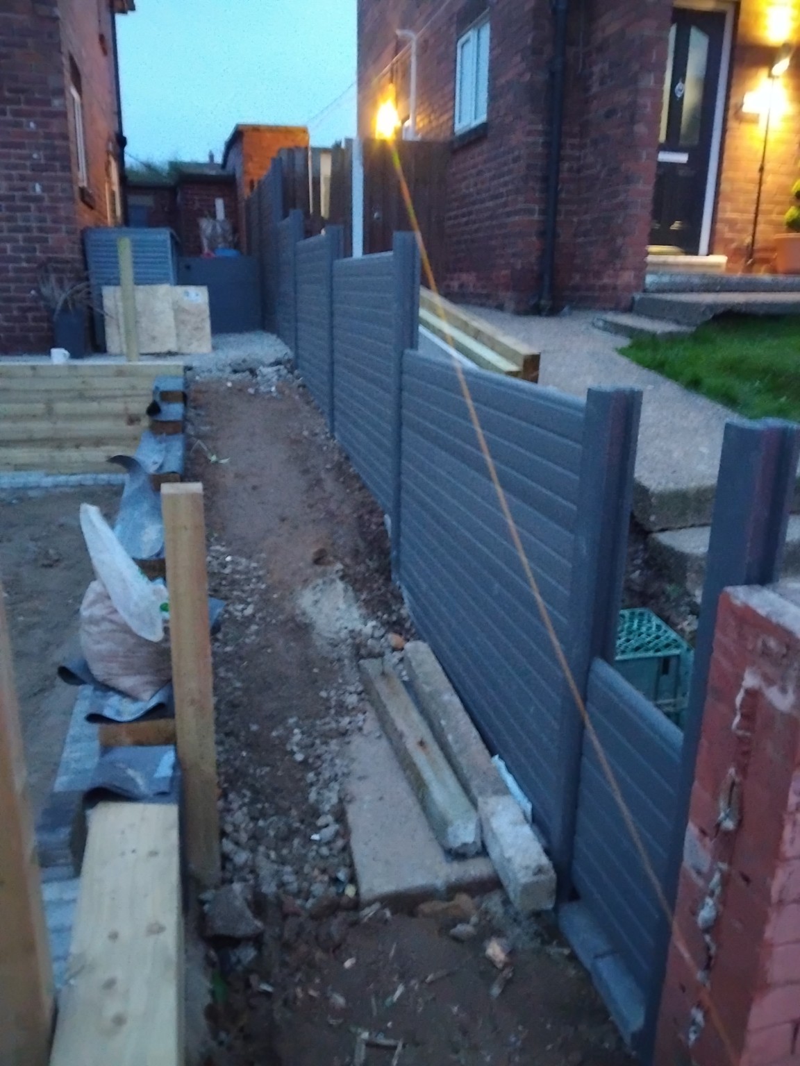Grey boundary fencing installed alongside the driveway works