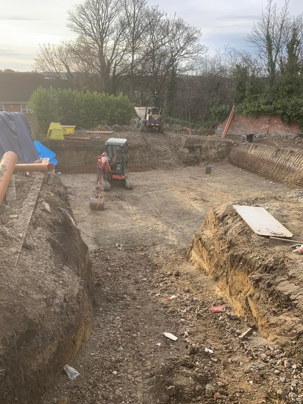 Excavated building site with a prepared base and groundwork machinery