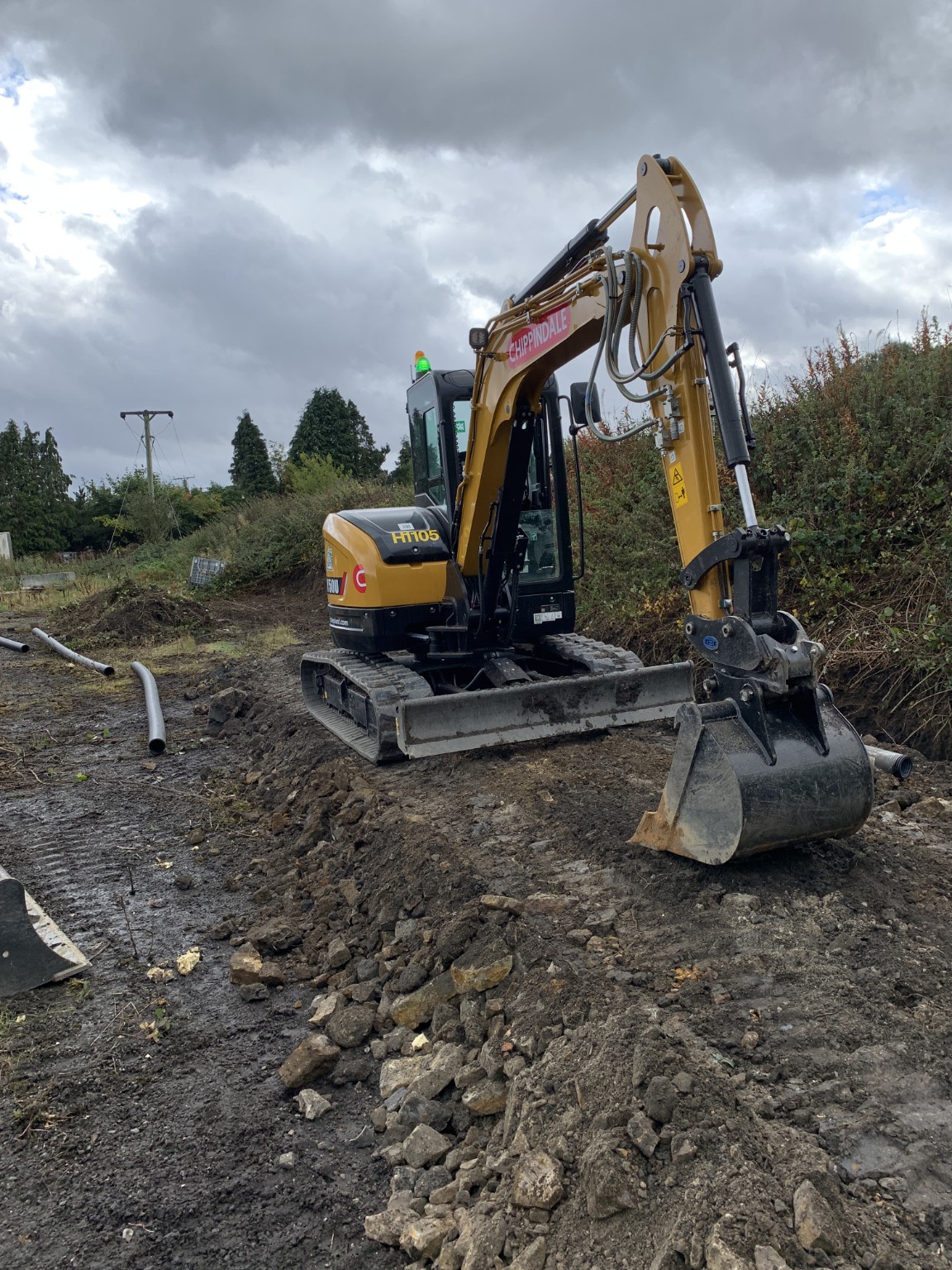 Excavator carrying out groundworks on an earth mound