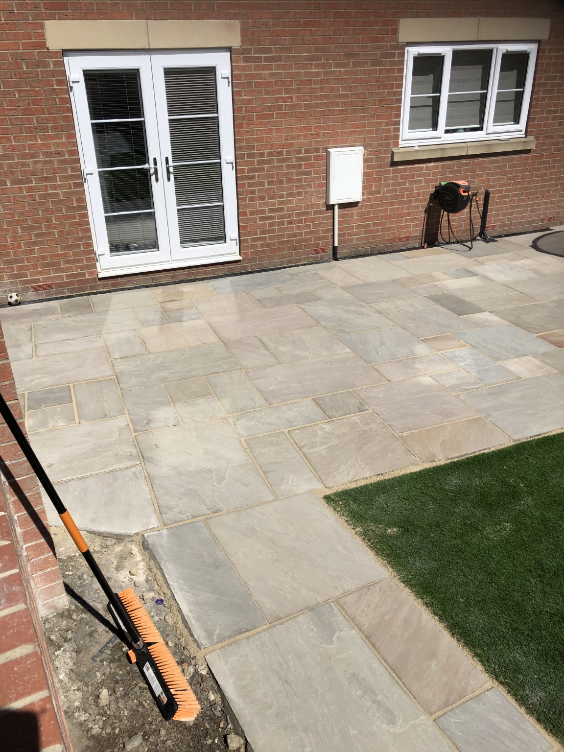 Pale paving creating a patio outside French doors