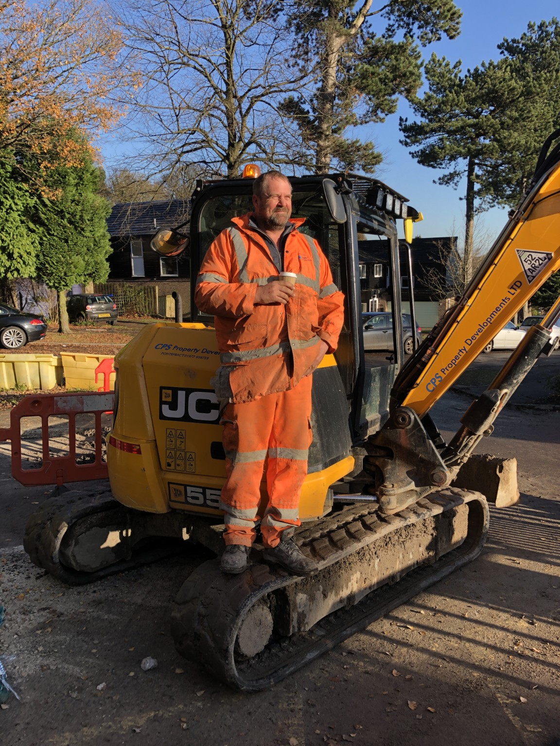 A member of the team beside a JCB excavator on site